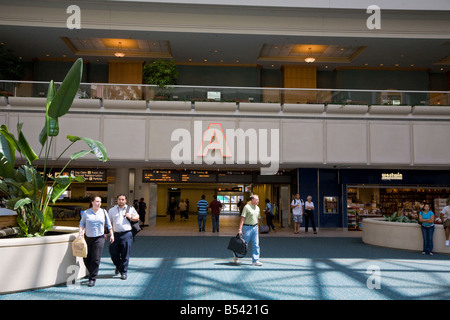 I viaggiatori di attendere per gli arrivi e le partenze in Orlando International Airport Terminal Foto Stock