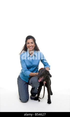 Felice Latina donna animali domestici cane al guinzaglio mentre lei si inginocchia Foto Stock