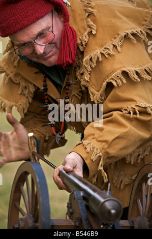 Uomo di indossare il costume di trapper dimostrando una polvere nera cannon a motore a vapore mostra a Westwold, British Columbia, Canada Foto Stock