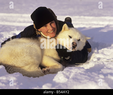 Husky e donna - giacenti in neve Foto Stock