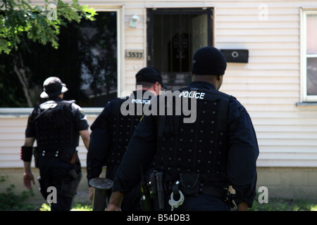 Funzionari di polizia da Detroit approccio Narcs una casa sospettato di trattare la droga Foto Stock