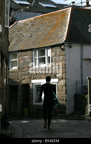 Surfer a piedi lungo la strada di St Ives Cornwall Inghilterra Foto Stock