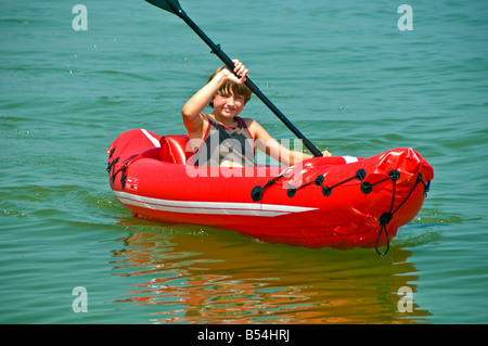 Ragazzo giovane adolescente kayak colore brillante rosso gonfiabile in PVC sit-in-top kayak Foto Stock