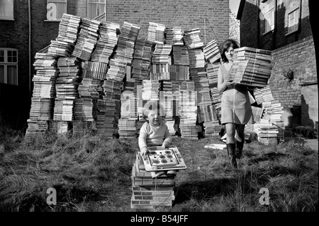 Babbo Natale viene presto per 14 mesi Patrick Flood, come suona con le importazioni in dumping di giochi, mentre sua madre la sig.ra Juddy Flood, recupera alcuni dei giochi dall'entrata posteriore a casa sua in Catford. Novembre 1969 Z10520-001 Foto Stock