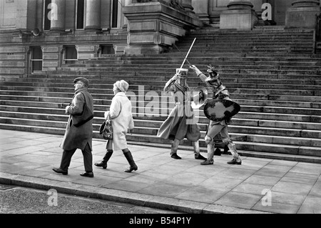 Shoppers fretta passato il Municipio passi come un paio di cavalieri medievali sono bloccati in combattimento a Bolton. La battaglia è stata filmata dalla Bolton Octagan Theatre Company. Dicembre 1969 Z11749 Foto Stock