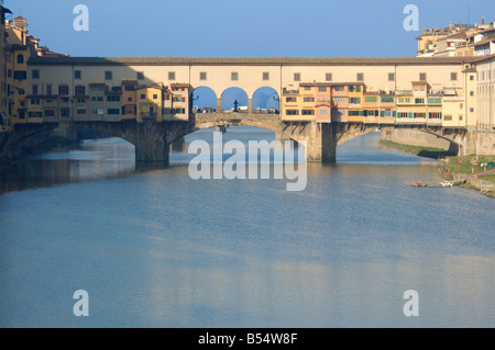 Un oriente vista del Ponte Vecchio ponte che attraversa il fiume Arno che mostra il Corridoio Vasariano che corre lungo la sezione superiore. Foto Stock