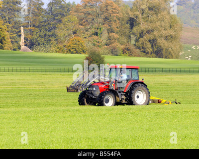 Fattoria di rosso il traino del trattore una grande macchina falciatrice Foto Stock