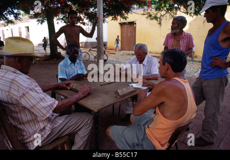 Gli uomini si radunano ogni giorno sotto l'ombra di un albero di gioco di domino - un ossessione nazionale - coloniale in Trinidad, Cuba Foto Stock