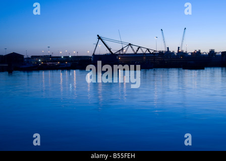 Sunrise dietro il dock in tutta l'acqua calma a Hythe ferry quay lato in Southampton Foto Stock