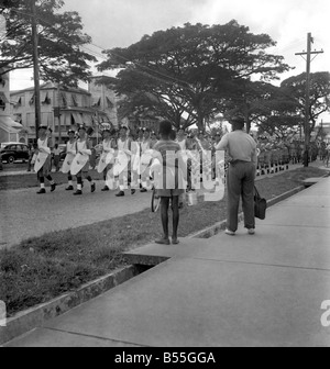 Soldati britannici marciando in Georgetown, Guiana britannica seguita da alcuni bambini. Le truppe sono state inviate per la calma di una grave crisi costituzionale whaich sorse in seguito alla elezione di quest'anno. • Ottobre 1953 ;D6229 Foto Stock