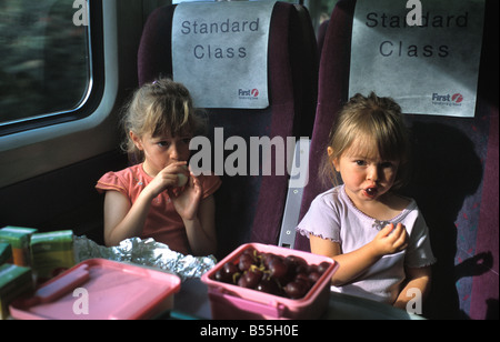 Due bambini su un primo grande treno occidentale di mangiare a un tavolo in un viaggio in treno Foto Stock