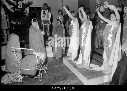 Un Hippie street cantante, e Maria spingendo una carrozzina, facevano parte di una scuola del corteo di Natale messo su dai figli di San James' Foto Stock