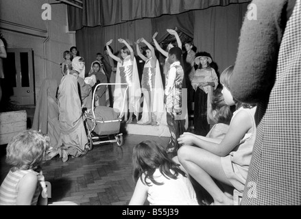 Un Hippie street cantante, e Maria spingendo una carrozzina, facevano parte di una scuola del corteo di Natale messo su dai figli di San James' Foto Stock