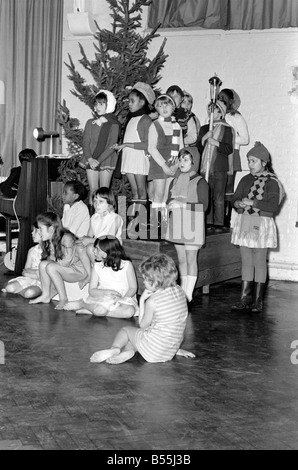 Un Hippie street cantante, e Maria spingendo una carrozzina, facevano parte di una scuola del corteo di Natale messo su dai figli di San James' Foto Stock