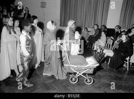 Un Hippie street cantante, e Maria spingendo una carrozzina, facevano parte di una scuola del corteo di Natale messo su dai figli di San James' Foto Stock