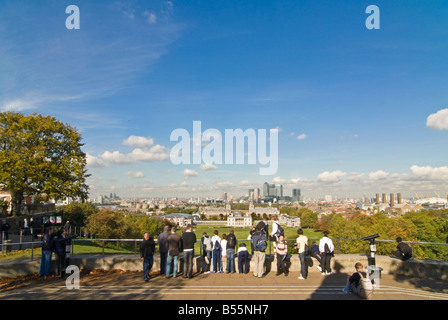 In orizzontale ampia angolazione di turisti su Greenwich Park Hill godendo la vista spettacolare su Greenwich Park verso Canary Wharf Foto Stock