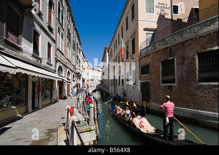 I turisti sulle gondole su uno stretto canale nel quartiere di San Marco, Venezia, Veneto, Italia Foto Stock