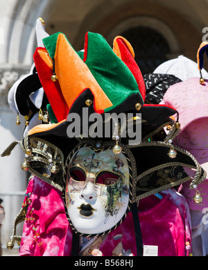 Stallo del mercato di vendita di maschere di carnevale e jester cappelli al di fuori del Palazzo Ducale, il Molo di San Marco, Venezia, Veneto, Italia Foto Stock