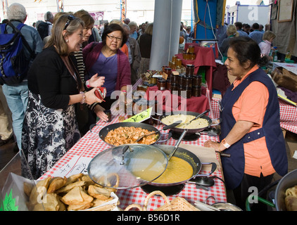 Donna che serve cibo indiano a Abergavenny Food Festival Wales UK Foto Stock