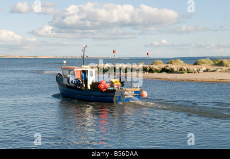 Barca da pesca a suo modo al mare, dal Mudeford Quay nel Dorset Foto Stock