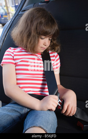 Ragazza il suo fissaggio cintura di sicurezza Foto Stock