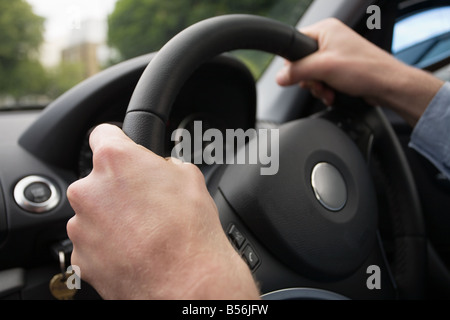 Le mani sul volante di sterzo Foto Stock