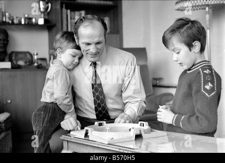 British boxer Henry Cooper nella foto con figli Henry Marco di età compresa tra i 10 (a destra) e 3 anni Giovanni Pietro giocando con una sommità di filatura gioco presso la sua casa di Wembley. Dicembre 1970 ;70-11690-001 Foto Stock