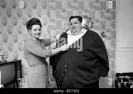 Mondo uomo Fattest: Sig.ra Gwen Matthewman raccordo 38-stone Arthur Armitage con il cardigan che ha avuto il suo 30 ore a lavorare a maglia per lui. Dicembre 1969 Z12233-005 Foto Stock