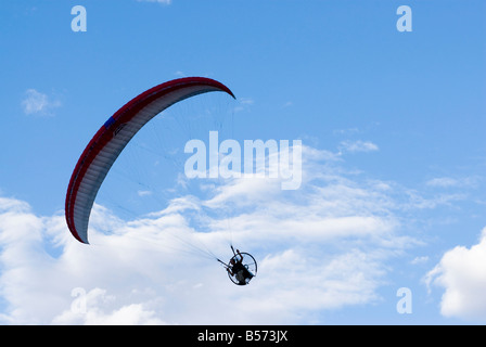 Pilota di parapendio in volo contro il drammatico nuvole Foto Stock