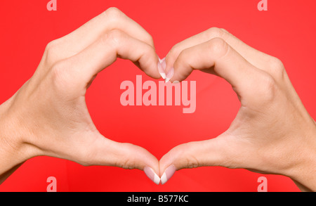 Primo piano delle mani femminili caucasiche che formano Un cuore. STATI UNITI Foto Stock