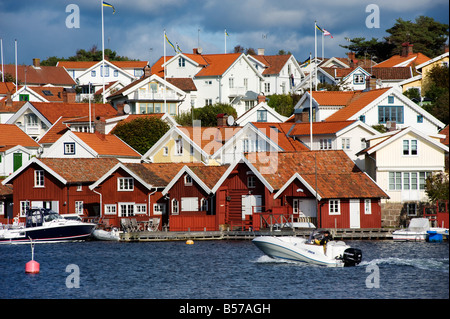 Case di legno dipinte con colori vivaci nel villaggio di pescatori di Fiskebackskil sulla costa di Swedens Bohuslan Foto Stock