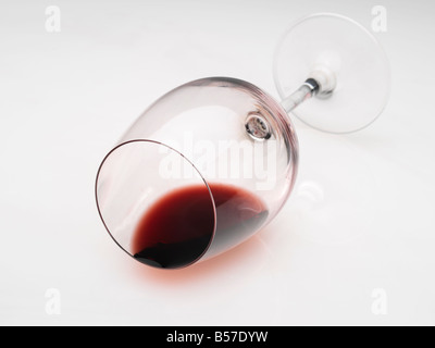 Bicchiere di vino rosso sul suo lato con il vino ancora in vetro Foto Stock