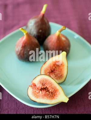 Ancora la vita intera tre figure e uno a fette sulla piastra blu Foto Stock