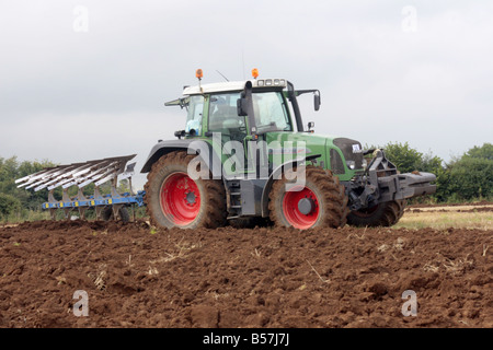 Gli agricoltori hanno una dura giornata di lavoro arare i campi del trattore. Foto Stock