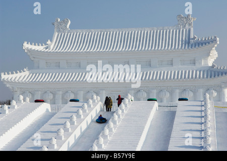 Ragazzo scorre verso il basso una gigantesca scultura di replica di Pechino la Città Proibita, Harbin, Heilongjiang, Cina Foto Stock