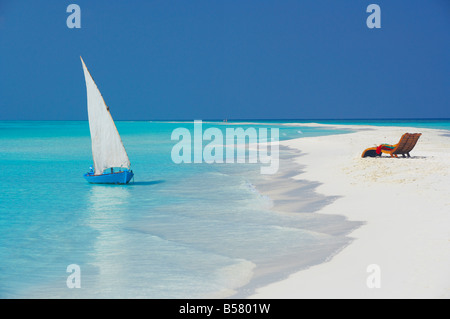 Tradizionale dhoni e sedie a sdraio sulla spiaggia, Maldive, Oceano Indiano, Asia Foto Stock
