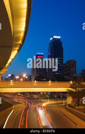 Auto sentieri di luce e di moderni edifici vicino Pechino stazione ferroviaria nord, Xizhimen District, Pechino, Cina e Asia Foto Stock