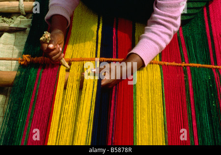 Una donna indiana tessitura di un tappeto nel piccolo villaggio dal Lago Titicaca, Bolivia, Sud America Foto Stock