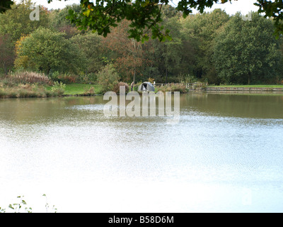 Un pescatore di acqua dolce impostando la sua linea accanto alla sua tenda sul lago presso Hardwick Hall,Hardwick,Derbyshire,l'Inghilterra,uk. Foto Stock