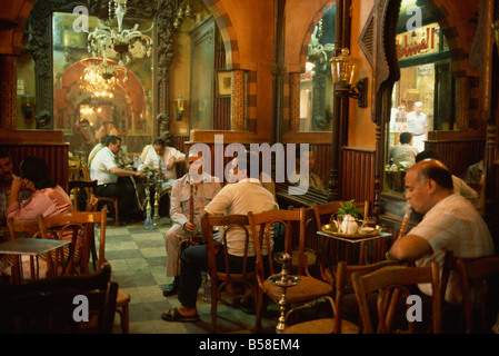 Gli uomini fumatori hookahs all'interno dell'El Fishawy Coffee House di Khan al-Kalili bazaar del Cairo in Egitto, Africa Foto Stock