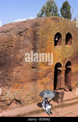 Pellegrino nel cortile di Bet Maryam (chiesa di San Mary's), con Bet Danaghel cappella dietro, Lalibela, Etiopia Foto Stock