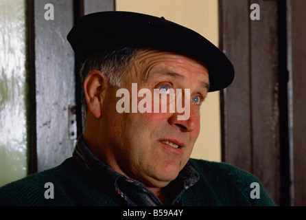 Victor Harriet indossando un berretto nero, un uomo che ancora rende il latte di pecora Formaggio denominato Brebis, in basco, Aquitaine, Francia Foto Stock