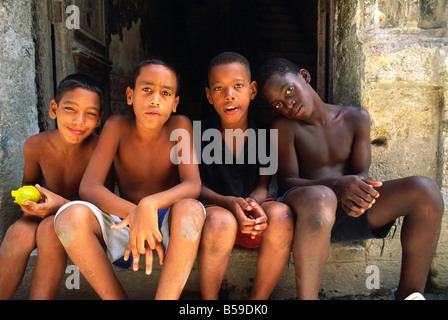 I ragazzi appendere fuori in uno stipite della porta nella antica citta' coloniale di Havana, Cuba Foto Stock