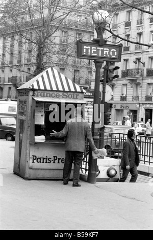 Un giornale del mattino reader ritira la sua carta da un chiosco nel quindicesimo distretto di Parigi, Francia. ;Aprile 1975 ;75-2079-008 Foto Stock