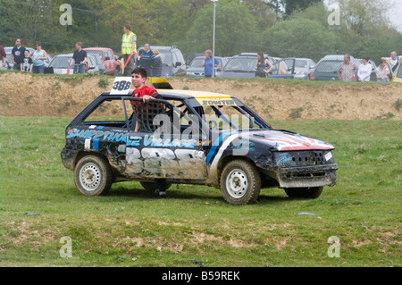 Autista uscendo di Banger Racing Car Smallfield canalina Surrey danneggiato autovetture rovinati Foto Stock