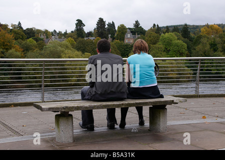 Coppia giovane seduto su un banco di lavoro dal fiume Tay Perth Scotland Regno Unito Foto Stock
