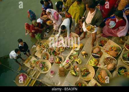 Offerte per il dio del sole Surya sul ghats durante il culto di Sun Festival Varanasi nello stato di Uttar Pradesh India Asia Foto Stock