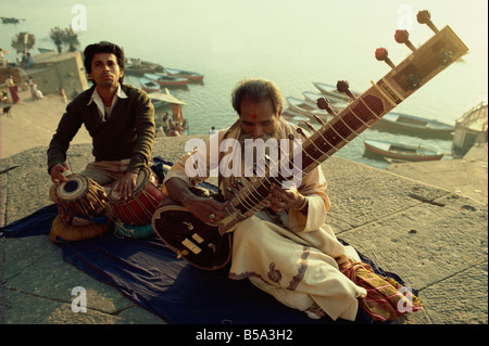 Sitar e tabla player accanto al fiume Ganga Varanasi nello stato di Uttar Pradesh India Asia Foto Stock