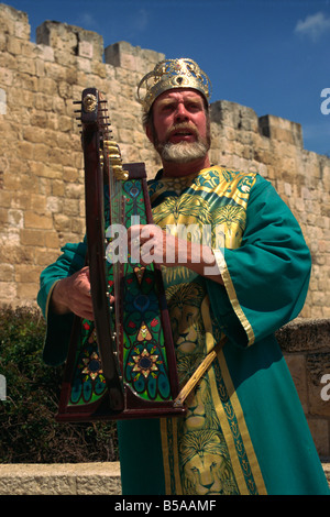 Ritratto di un uomo con arpa indossando abiti tradizionali di cantare davanti alle mura della città di Gerusalemme, Israele, Medio Oriente Foto Stock