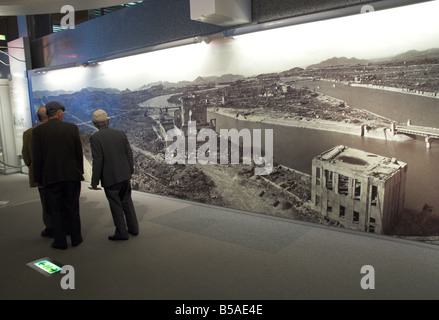 Per i visitatori in cerca di enormi poster mostrante la distruzione della città dopo la bomba atomica di Hiroshima, Honshu, Giappone Foto Stock